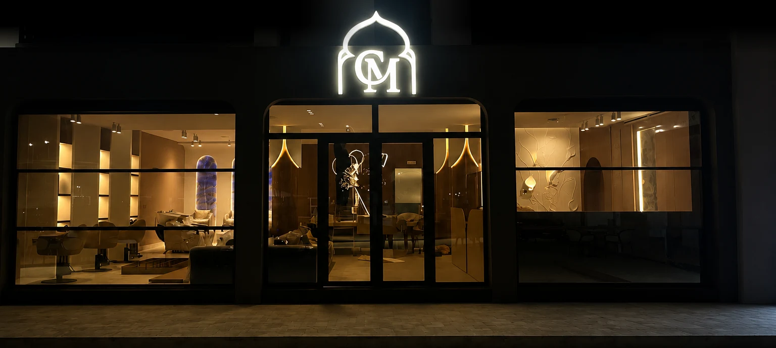 La façade de Costamar la nuit, monogramme lumineux au-dessus des portes vitrées